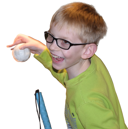 A young blind boy smiles while playing with a ball.